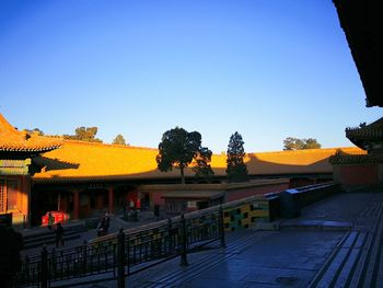 Panoramic view of yellow and buildings against clear blue sky