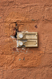 Close-up of old telephone booth on wall