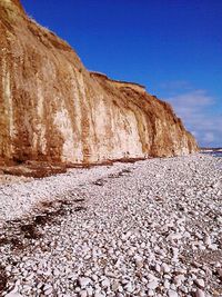 Surface level of rocks against blue sky