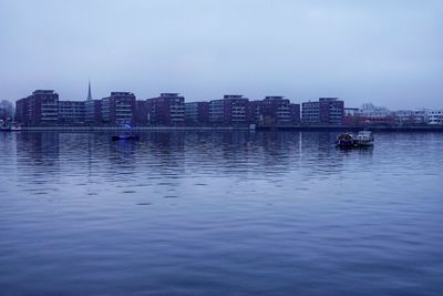 Scenic view of sea by buildings against sky