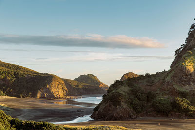 Scenic view of sea and mountains against sky