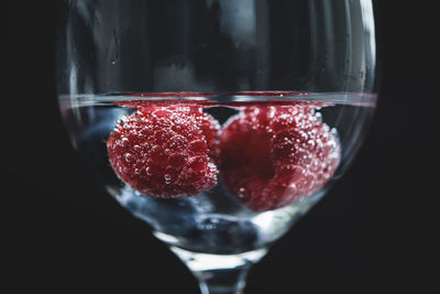 Close-up of strawberries in glass against black background