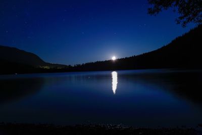 Scenic view of lake against clear blue sky at night