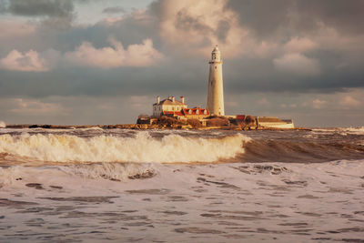 St mary's lighthouse behind waves in the sea