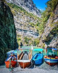 Boats moored on rocks by sea