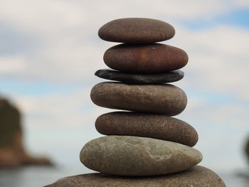 Close-up of stone stack on rock against sea