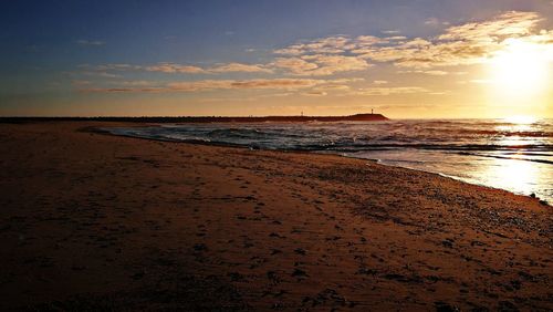 Scenic view of beach against sky during sunset