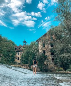 Rear view of woman standing against old building