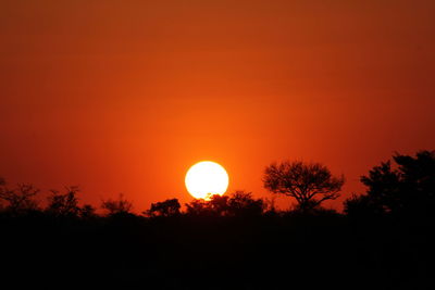 Scenic view of silhouette landscape against orange sky