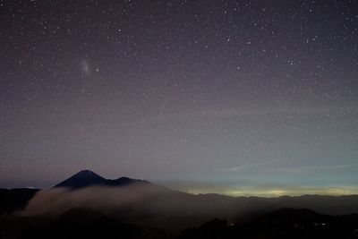 Scenic view of silhouette mountains against sky at night