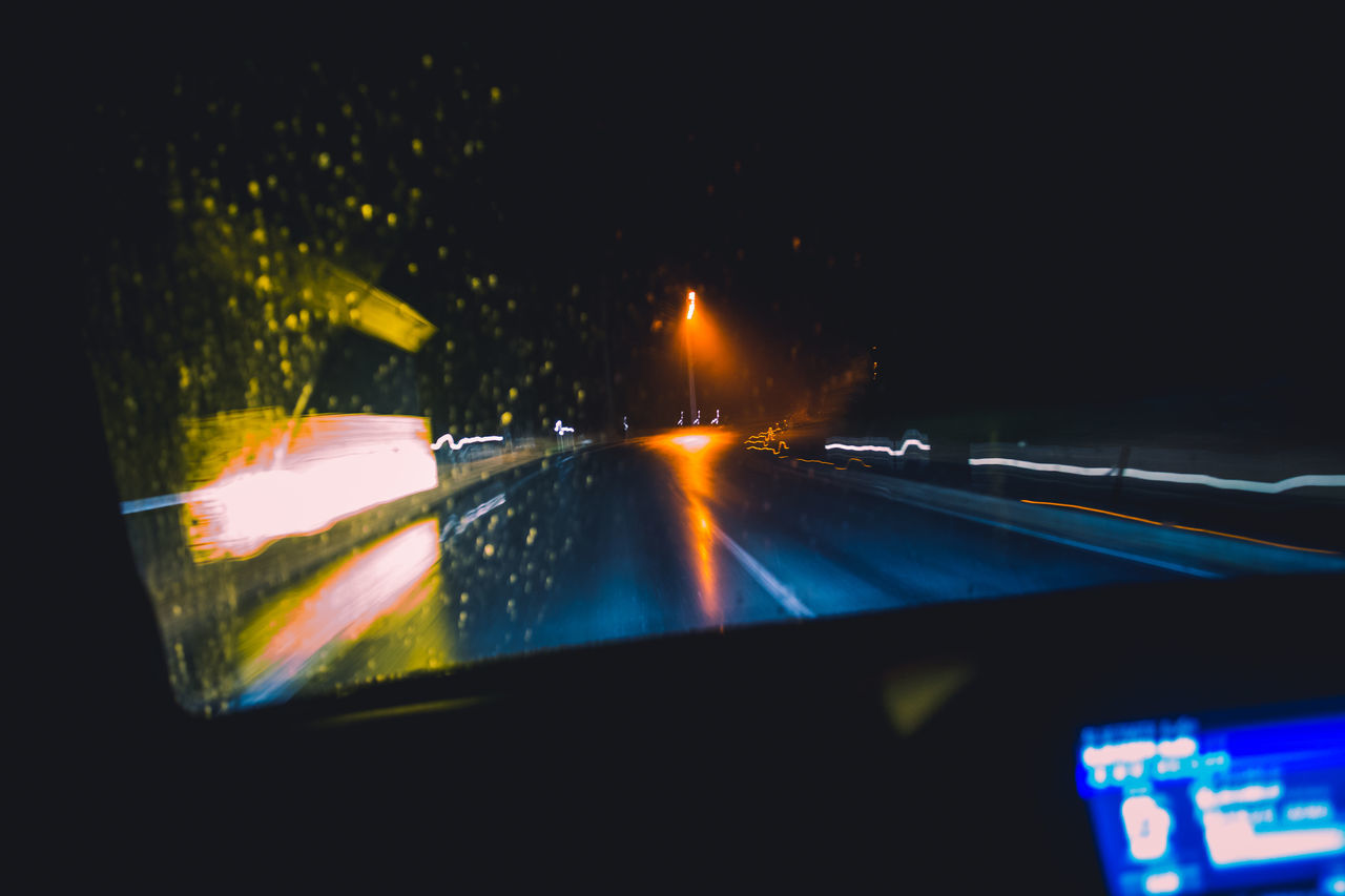 ILLUMINATED STREET SEEN THROUGH CAR WINDSHIELD