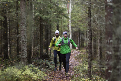 Man and woman running in forest