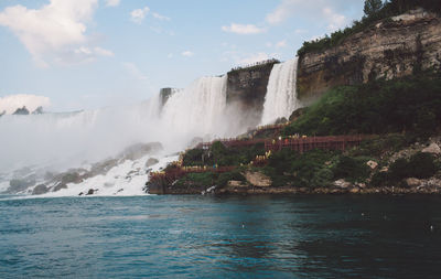 Scenic view of waterfall against sky