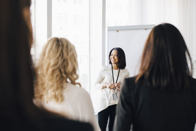 Female entrepreneur talking to colleagues in office seminar