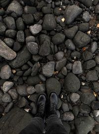 Low section of person standing on pebbles