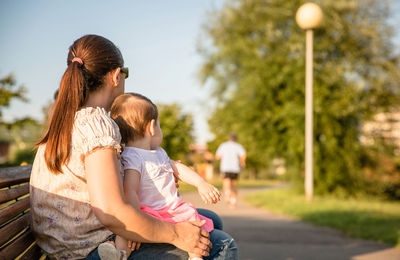 Rear view of mother and girl standing outdoors