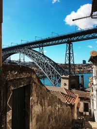 Low angle view of bridge and buildings against sky