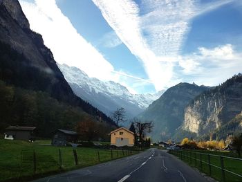 Road by mountains against sky