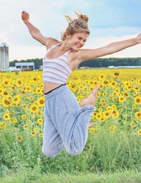 Young woman with yellow flowers on field