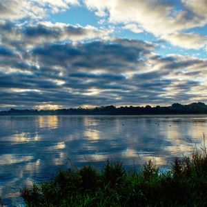 Scenic view of lake against cloudy sky