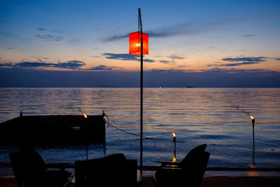 Lifeguard hut at sea against sky during sunset