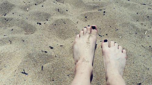 Low section of woman feet in  sand