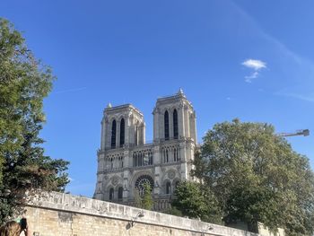 Low angle view of trees and building against sky