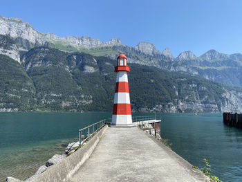 Lighthouse by sea against sky