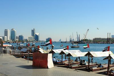 Lounge chairs on beach against buildings in city