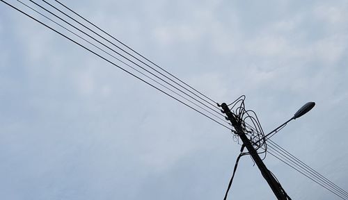 Low angle view of electricity pylon against sky