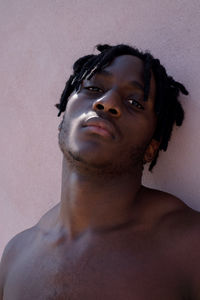 Young black man next to the pink wall portrait