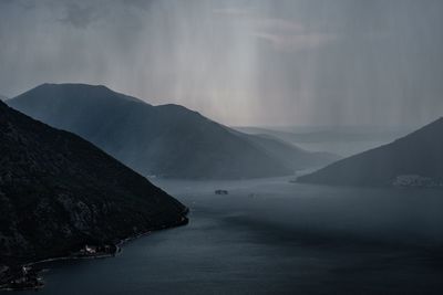 Scenic view of sea and mountains against sky