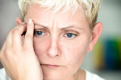 Close-up of blond woman with headache