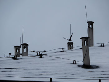 Street lights on snow covered field against clear sky