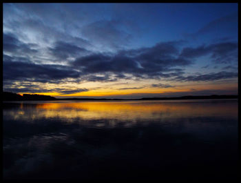 Scenic view of lake against cloudy sky