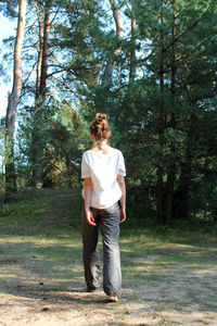 Full length of teenage girl standing in forest
