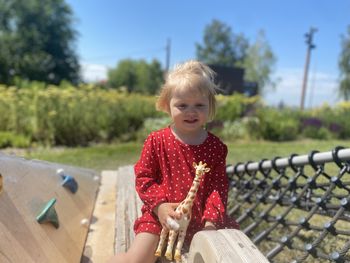 Portrait of cute girl sitting on field