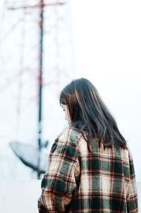 Rear view of young woman standing outdoors