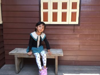 Portrait of smiling girl sitting on bench