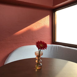 Close-up of flower vase on table against wall