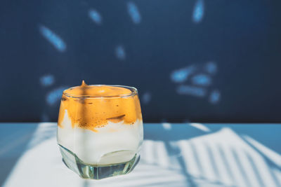 Close-up of dalgona coffee drink in glass on table