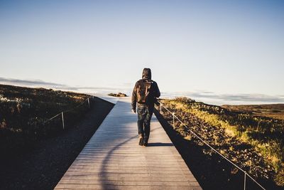 Rear view of man on road against sky