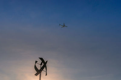Low angle view of silhouette airplane flying in sky