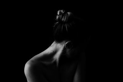 Portrait of shirtless woman against black background