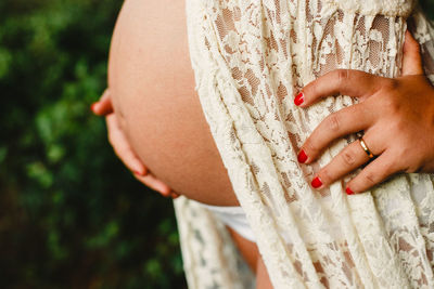 Midsection of pregnant woman standing outdoors