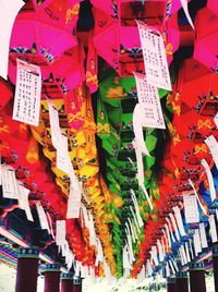 Close-up of multi colored flags hanging on paper