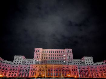 Low angle view of illuminated building against sky at night