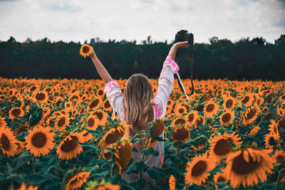 Full length of woman with flowers on field