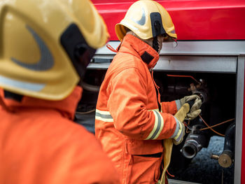 Firefighters working by fire engine 