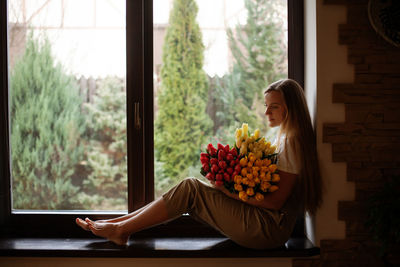 Woman sitting on window sill